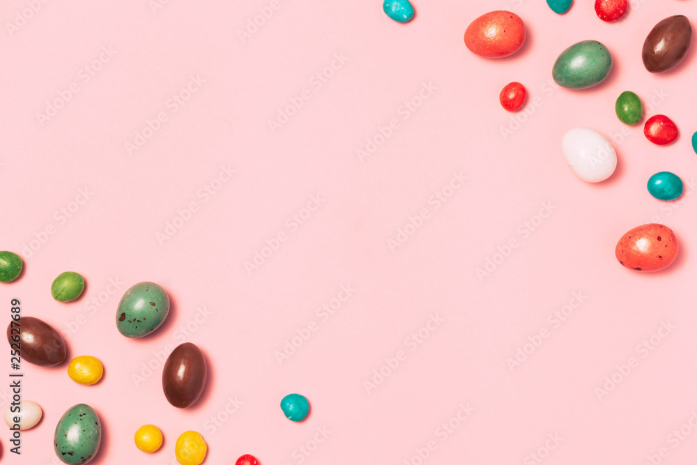 Easter frame made from colorful eggs and big chocolate egg flat lay on white background. Top view, copyspace for text. Easter frame made from colorful eggs and big chocolate egg flat lay on white background. Top view, copyspace for text.