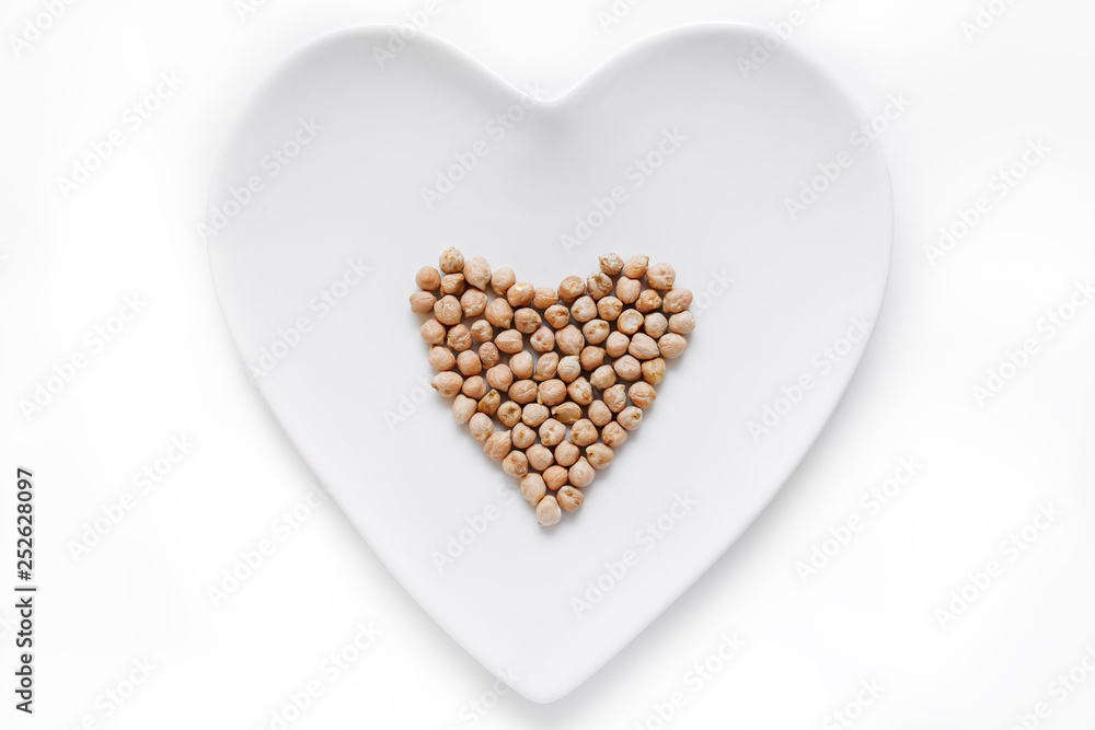 Grain chickpeas is in the shape of a heart on a white plate