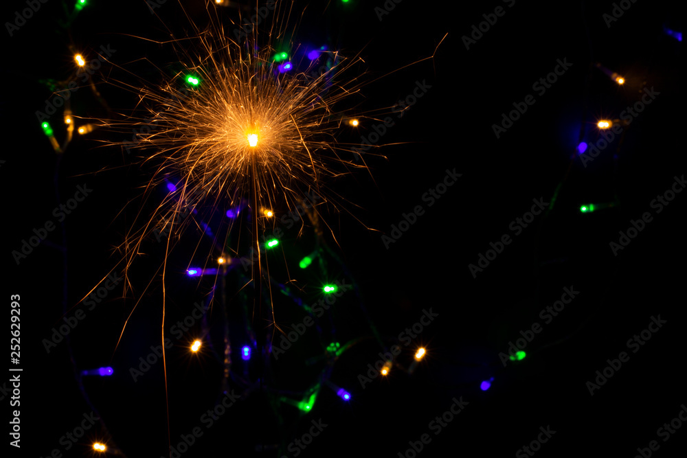 Fototapeta premium sparkler with blur new year's light close up