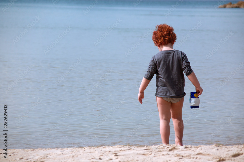 Red-haired child on the background of the sea Red-haired child on the background of the sea