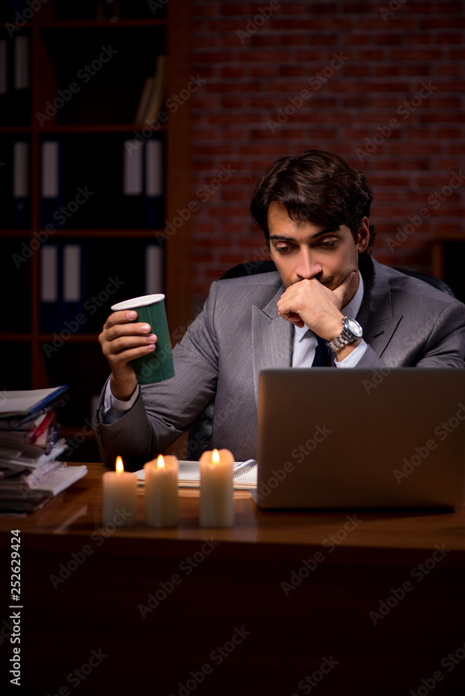 Businessman working late in office with candle light Businessman working late in office with candle light