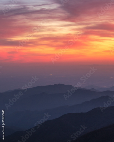 A beautiful orange and pink sky over layered silhouetted mountains during sunset. Kings Canyon National Park. 