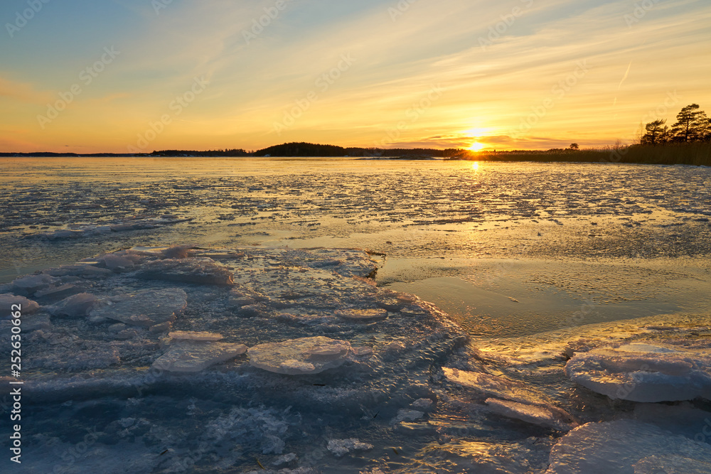 Obraz premium Frozen beach and icy sea on a sunset in Ruissalo, Finland. 