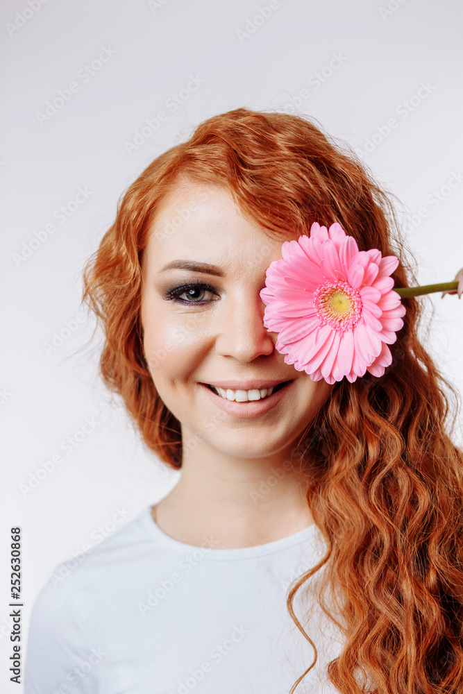 Naklejka premium Young woman holding flower over her face