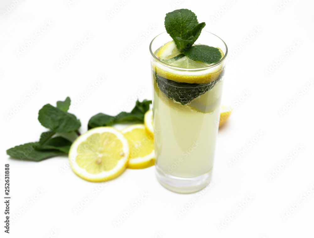 Fototapeta premium a glass of fresh lemonade, against a background of lemons and mint, isolated on a white background.