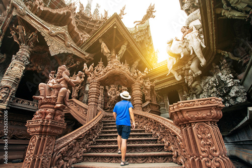 A man tourist is sightseeing inside the Ancient wooden Sanctuary of Truth in Pattaya, Thailand.