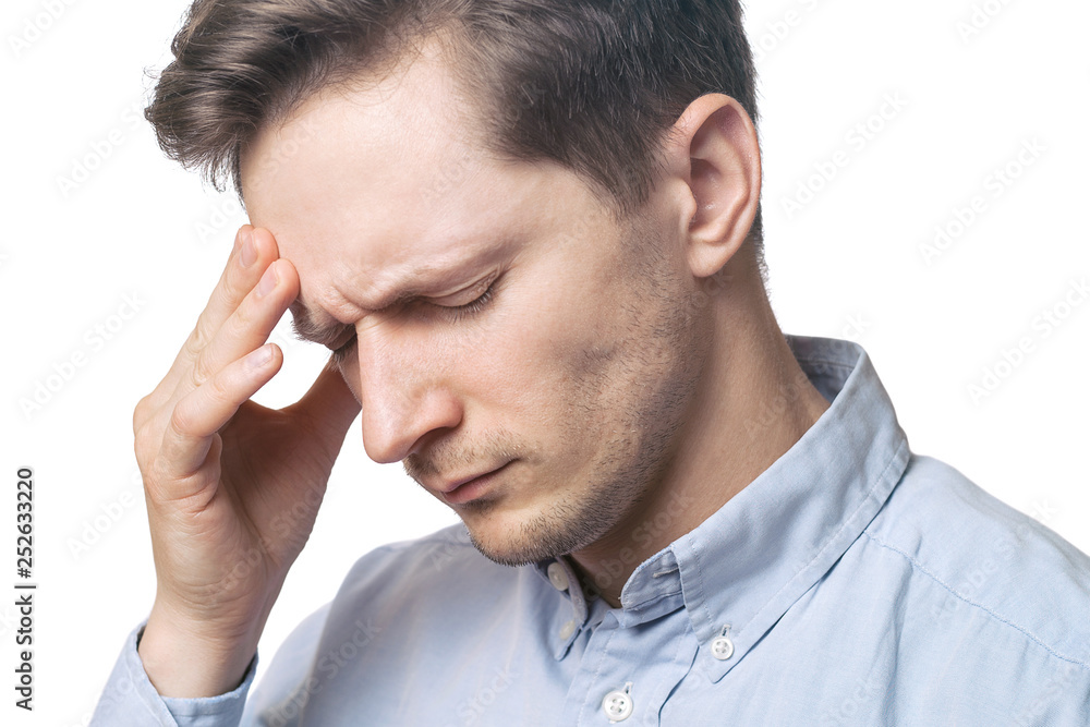 close up of tired young man suffering from headache on white background close up of tired young man suffering from headache on white background