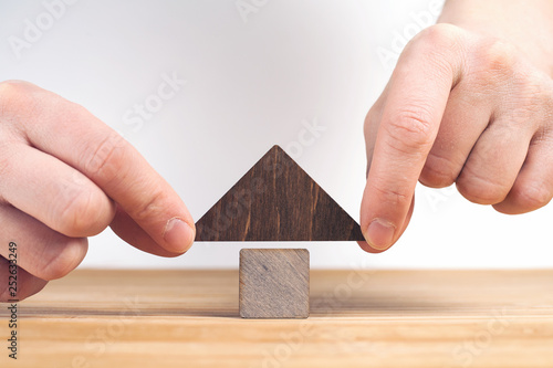 Real estate concept. Wooden house model on wooden table, white background