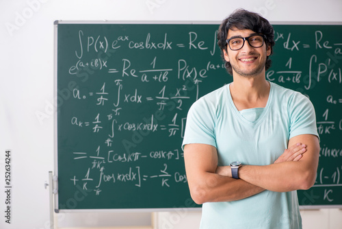 Photo Young male student mathematician in front of chalkboard