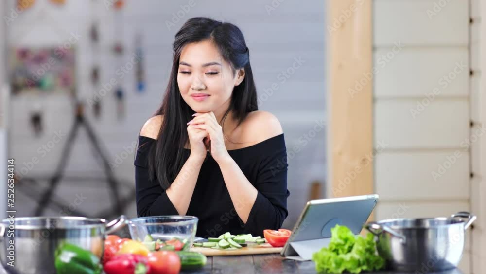 Portrait of adorable young Asian girl smiling and posing looking at camera in kitchen Portrait of adorable young Asian girl smiling and posing looking at camera in kitchen
