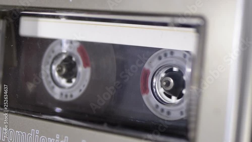 Audio Cassette is inserted into the Deck of the Audio Tape Recorder Playing and Rotates photo