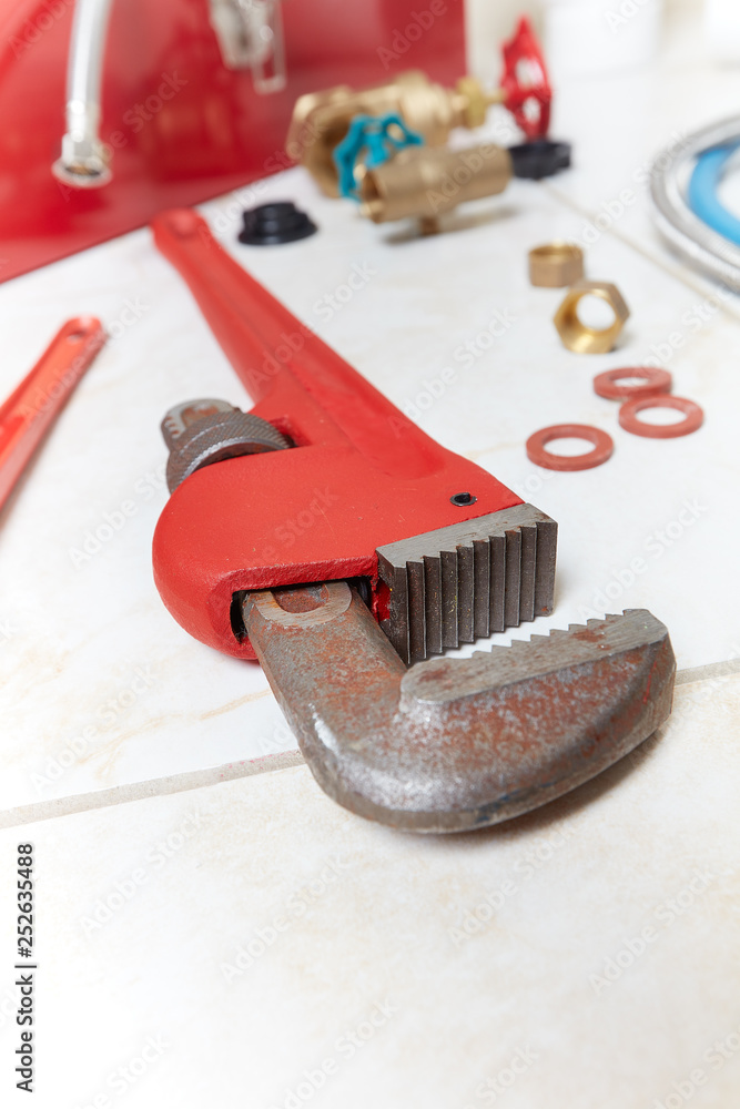 Plumbing wrench on the bathroom ceramic floor. Plumbing wrench on the bathroom ceramic floor.