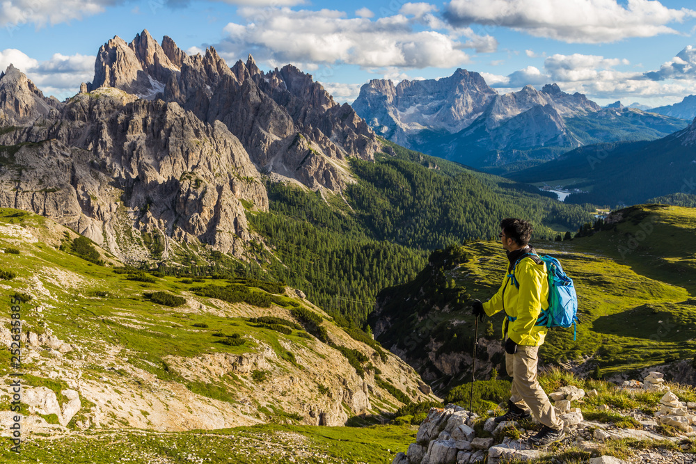 Male asian hiker looking at majestic view of Dolomites moutain range in Tre Cime di Lavaredo trail