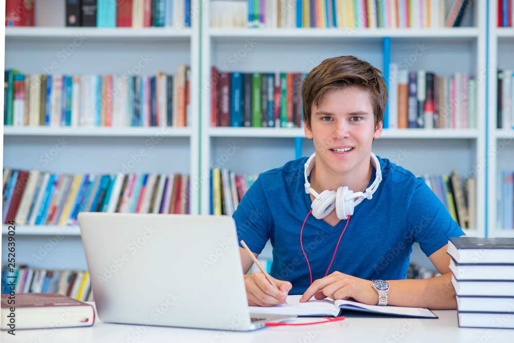 student preparing exam and learning lessons in school library, making research on laptop and browse internet student preparing exam and learning lessons in school library, making research on laptop and browse internet