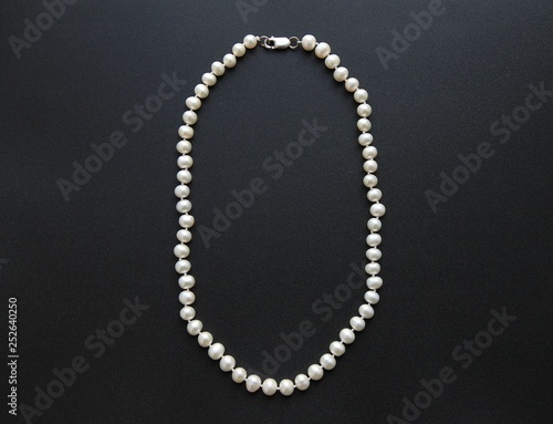 white necklace on black background