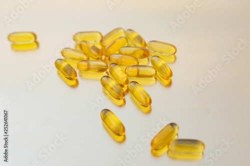 Omega-3 fish oil gelatin softgels on gold background. Fatty Acids. Health care concept