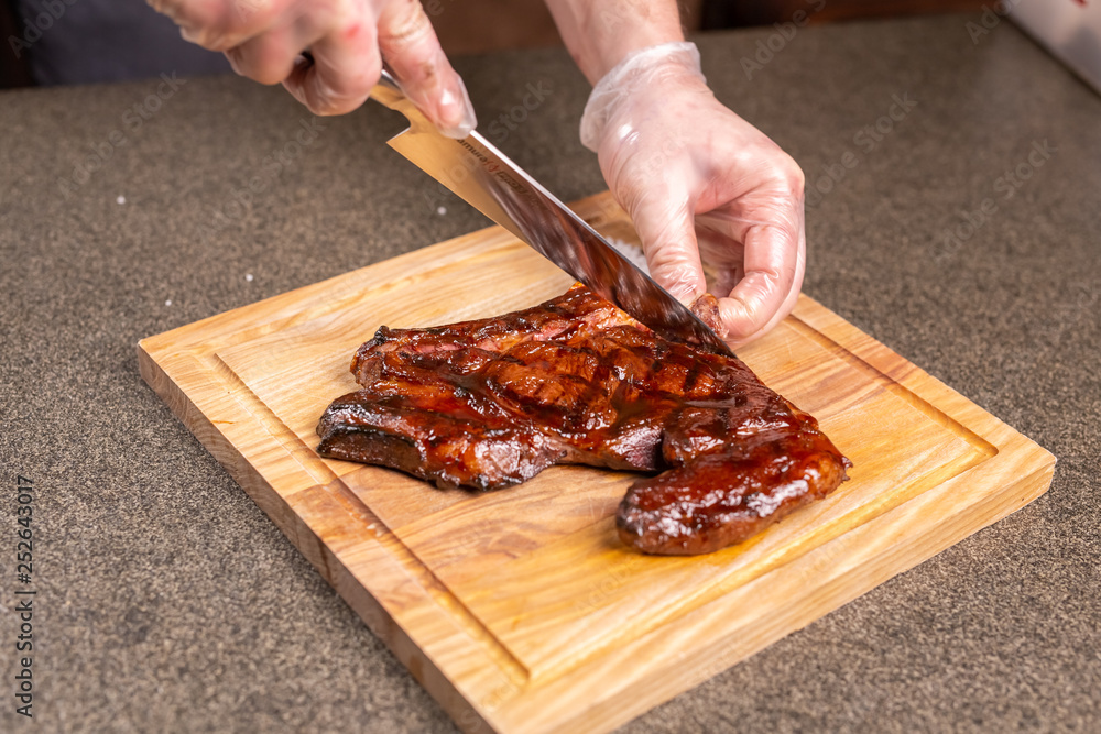 food, delicious and craft concept - Man cutting horse steak