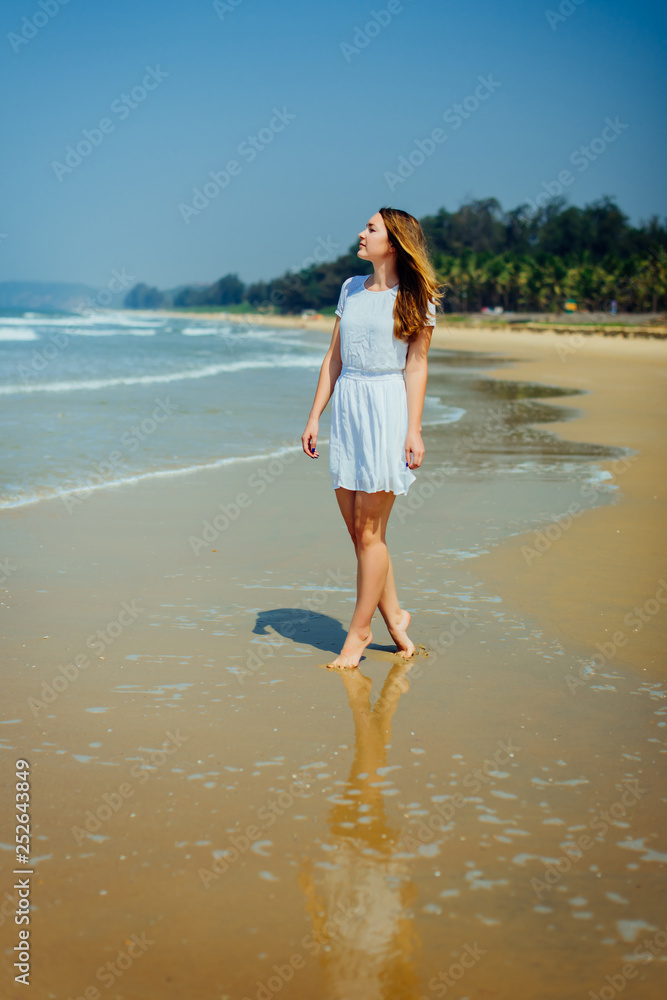 Beautiful Girl in White Dress Enjoy and Relax on The Beach. Travel and Vacation. Beautiful Girl in White Dress Enjoy and Relax on The Beach. Travel and Vacation.