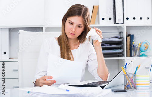 Upset young businesswoman in office