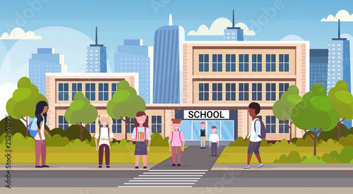 group of mix race pupils walking in front of school building primary schoolchildren near crosswalk back to school concept cityscape background flat full length horizontal