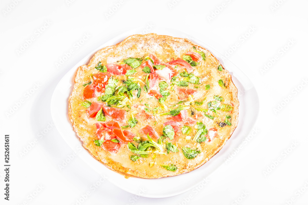 Omelette with tomatoes and fresh corn salad on a white background Omelette with tomatoes and fresh corn salad on a white background