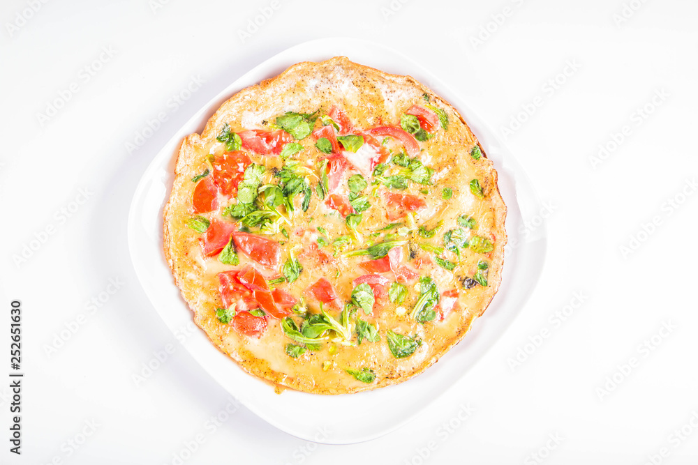 Omelette with tomatoes and fresh corn salad on a white background Omelette with tomatoes and fresh corn salad on a white background