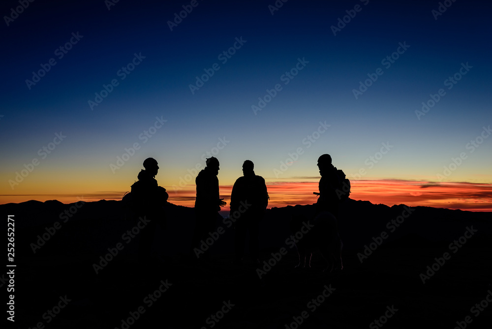 Gruppo, quattro persone, osservano l'alba in montagna