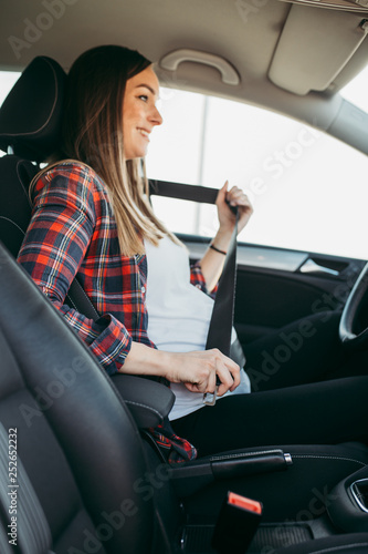 Pregnant woman driving with safety belt on in the car.