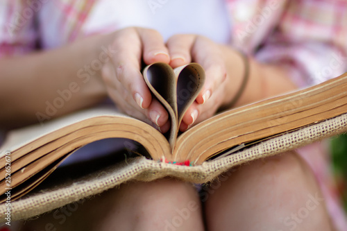 An old book in the hands of a woman. 