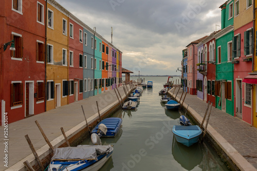 Burano Island - part of Venice, colored houses on the background of the channel. © Anna