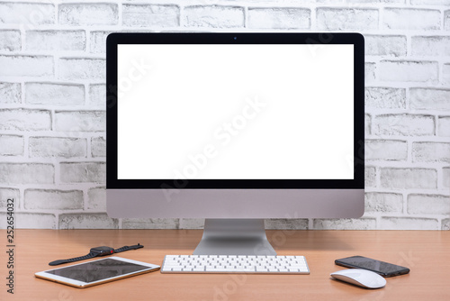 Blank screen of All in one Computer with tablet, smart phone and smart watch on wooden table, White brick wall background