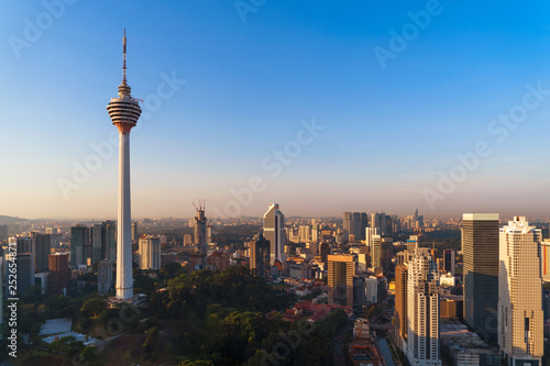Menara Kuala Lumpur Tower with sunset sky. Aerial view of Kuala Lumpur Downtown, Malaysia. Financial district and business centers in urban city in Asia. Skyscraper and high-rise buildings at noon.