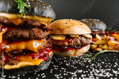 Many different burgers with ingredients on a black background