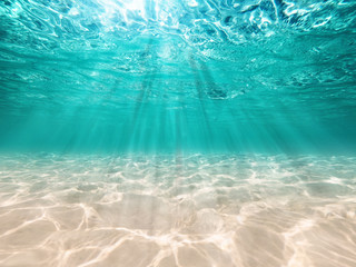 underwater background  deep blue sea and beautiful light rays with sandy floor