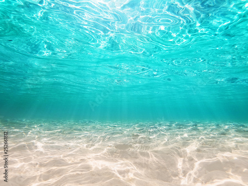 underwater turquoise background  deep blue sea and beautiful light rays with sandy floor