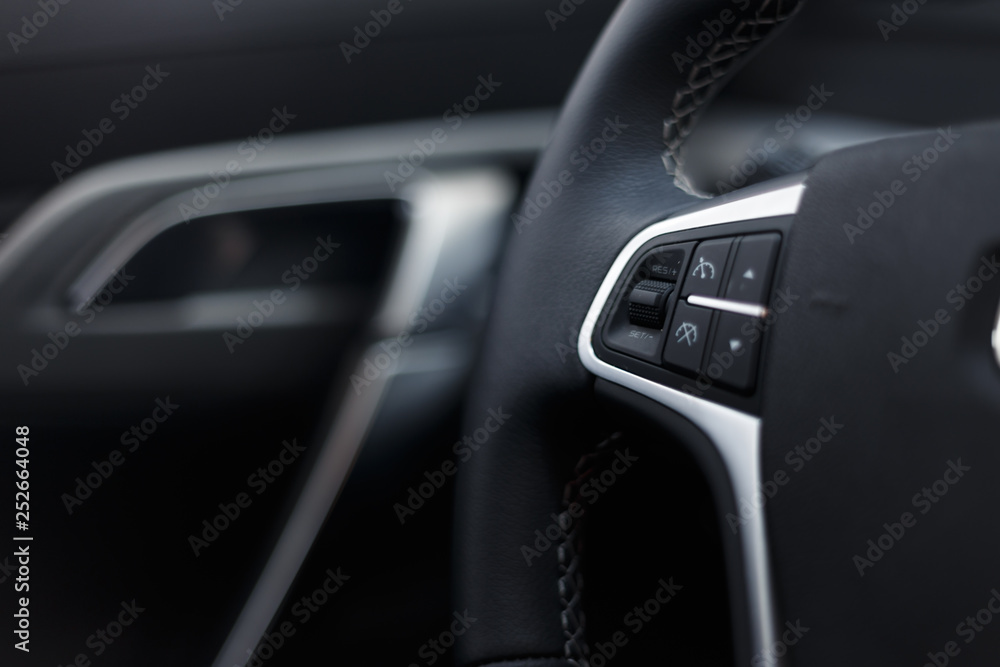 Multimedia leather steering wheel in a modern expensive car. Perforated leather steering wheel. Modern car interior details. Car detailing. Selective focus Multimedia leather steering wheel in a modern expensive car. Perforated leather steering wheel. Modern car interior details. Car detailing. Selective focus