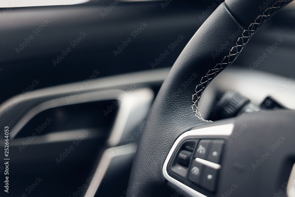 Multimedia leather steering wheel in a modern expensive car. Perforated leather steering wheel. Modern car interior details. Car detailing. Selective focus