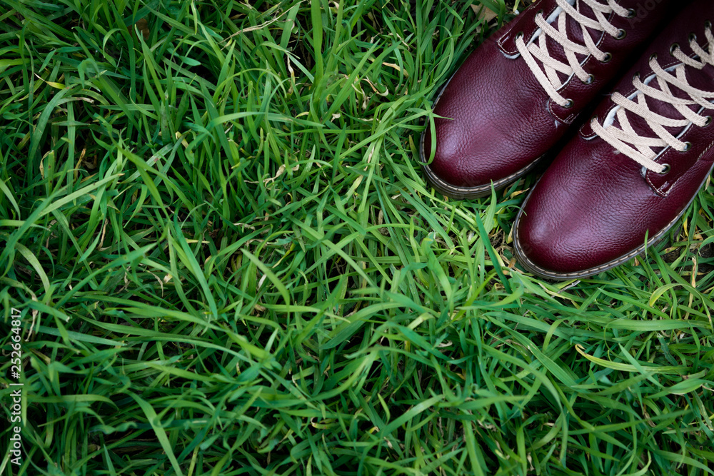pair of red boots on the green grass, upper point of view pair of red boots on the green grass, upper point of view