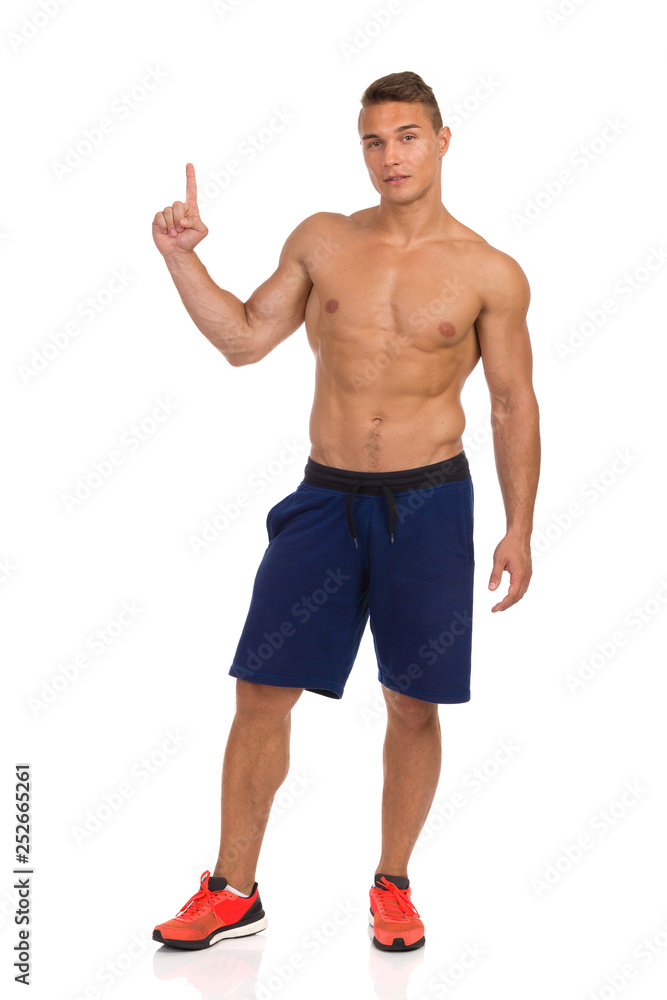 Half Naked Fit Man Is Standing Relaxed And Pointing Up Half Naked Fit Man Is Standing Relaxed And Pointing Up
