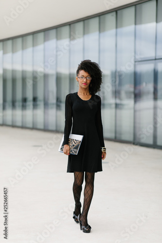 Young urban stylish businesswoman outside corporate building.