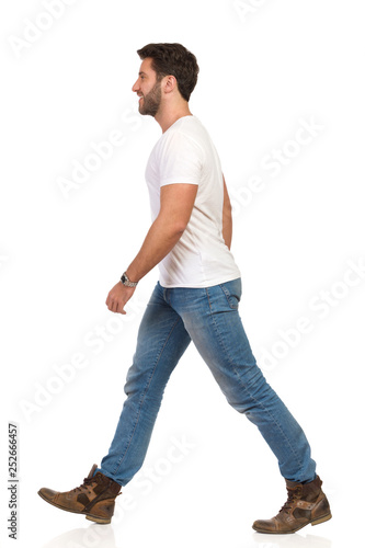 Walking Man In White T-shirt, Jeans And Boots