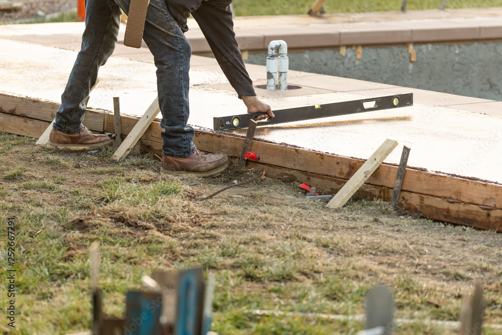 Construction Worker Checking Level On Wet Deck Cement Construction Worker Checking Level On Wet Deck Cement