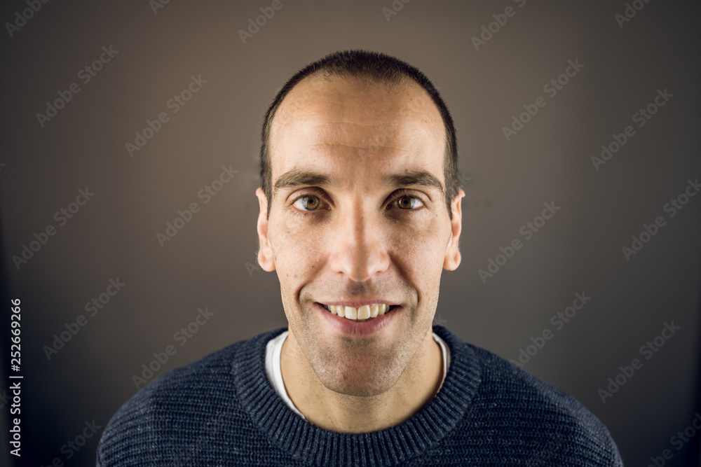 Portrait of a young man looking at the camera with happy expression and smiling Portrait of a young man looking at the camera with happy expression and smiling