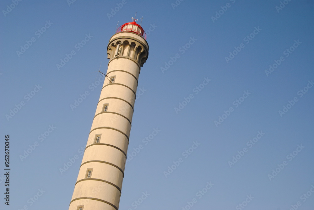 Topo de um farol com céu azul de fundo