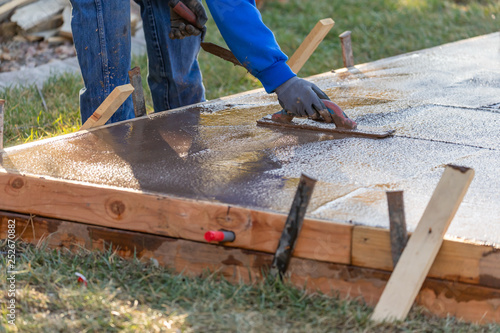 Construction Worker Smoothing Wet Cement With Trowel Tools