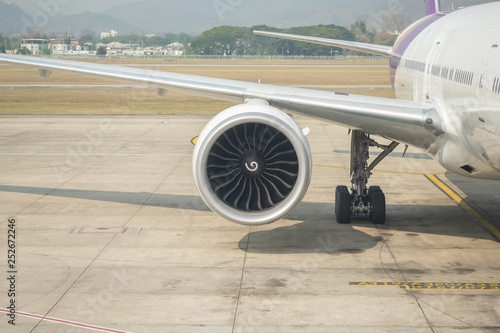Close up of airplane jet engine on ground at airport.