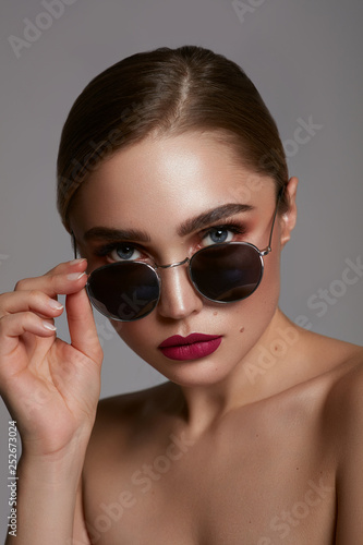 Portrait of young girl wear sunglasses isolated over gray background