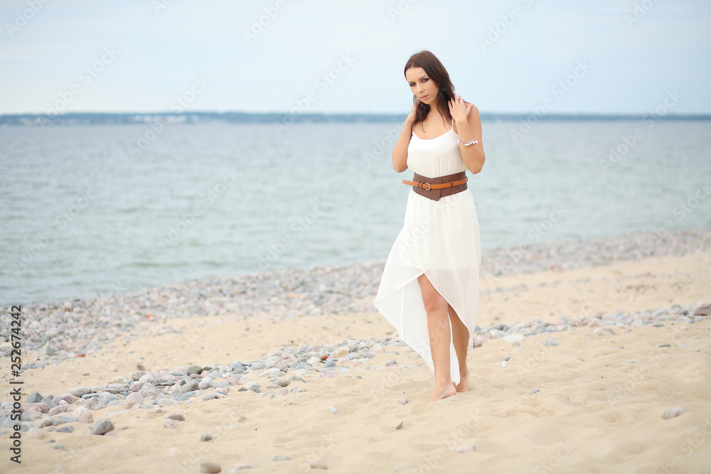 Gorgeous dark-haired girl in dress on sandy beach Gorgeous dark-haired girl in dress on sandy beach