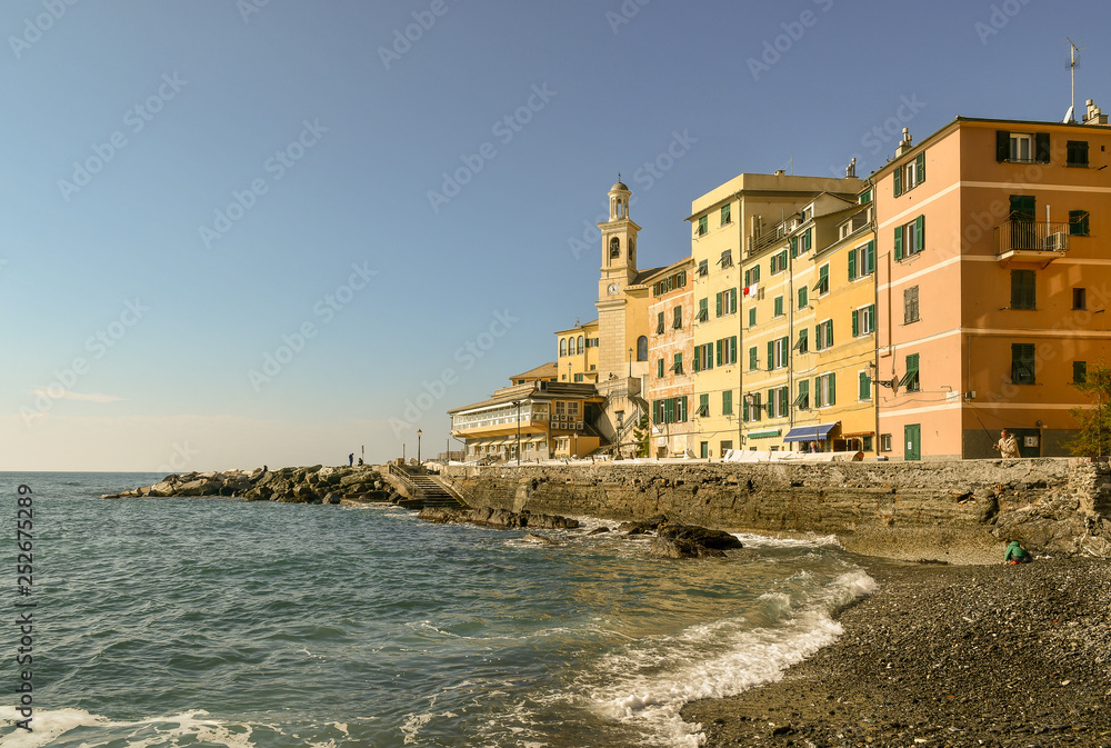 Scenic view from the little beach of the old fishing village of Boccadasse with the typical colored houses and the rocky pier, Genoa, Liguria, Italy