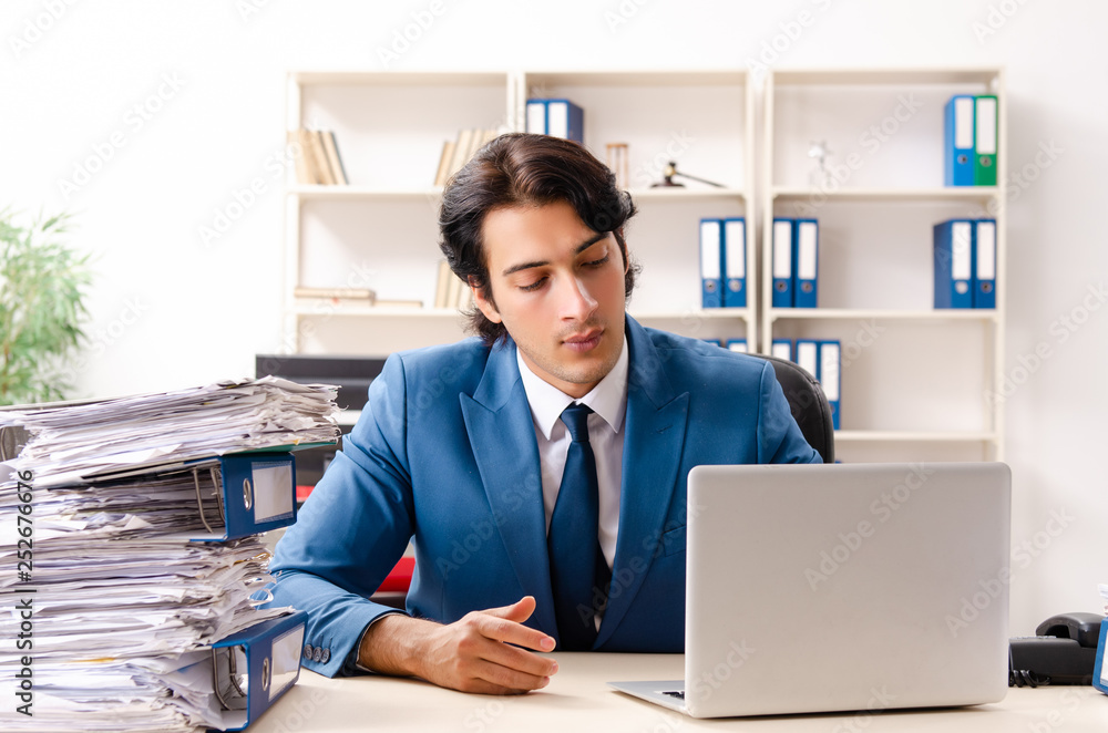 Young handsome busy employee sitting in office Young handsome busy employee sitting in office